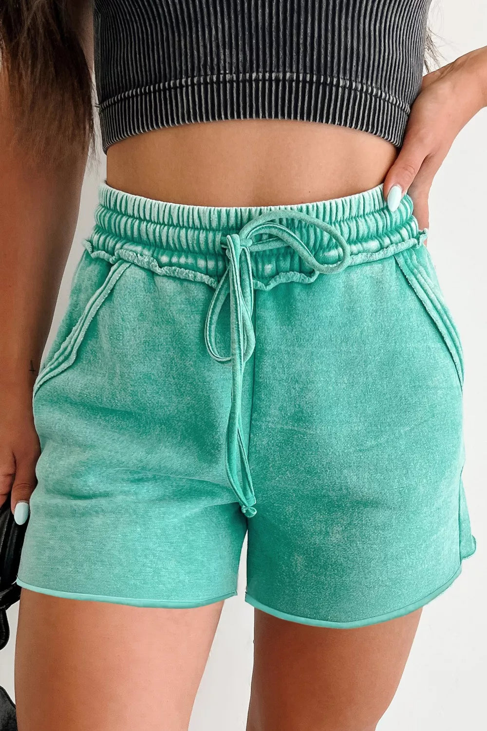 Mineral washed green cotton drawstring shorts with elastic waist and pockets.