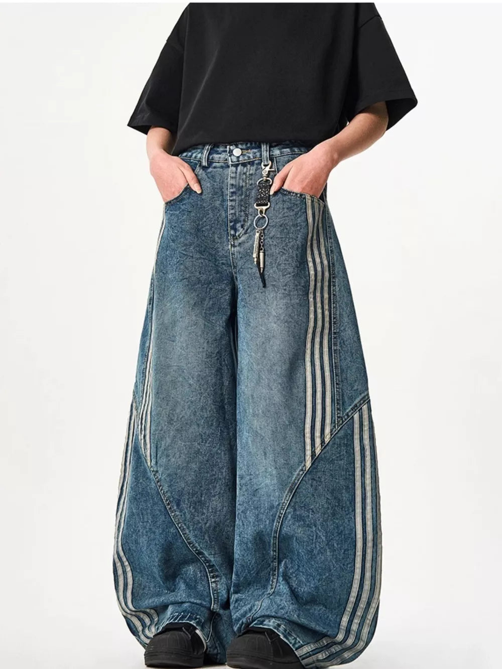 Blue acid-wash wide-leg jeans with triple stripe detail and keychain accessory.