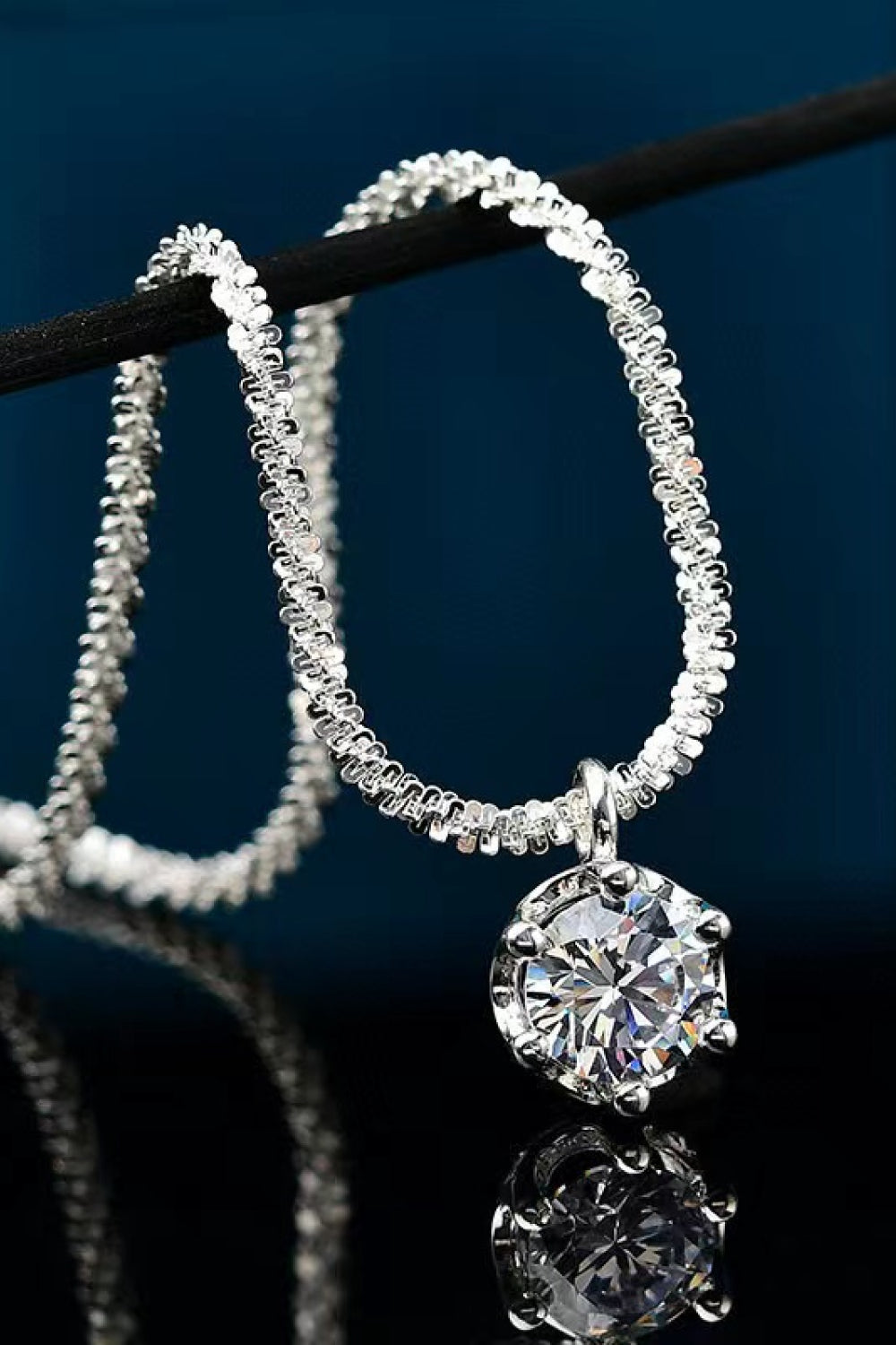 Silver textured halo moissanite pendant necklace with a round-cut stone.