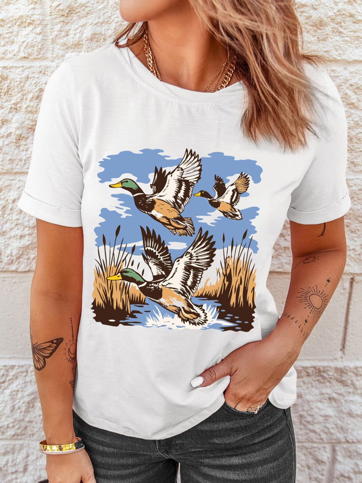 White cotton tee with a graphic of three ducks flying over reeds and water.