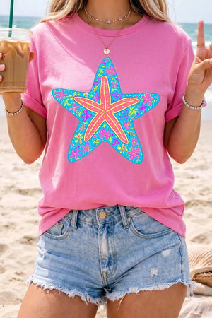 Pink t-shirt with a blue starfish graphic filled with colorful flowers.