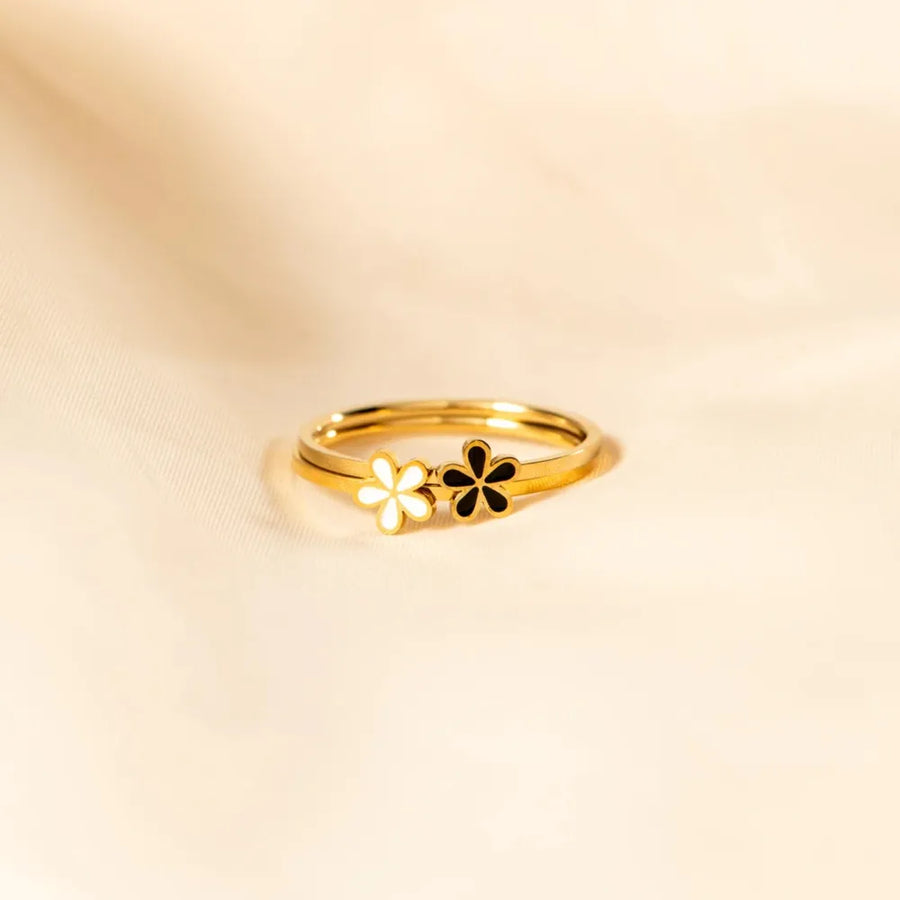 Delicate gold rings with white and black floral enamel details