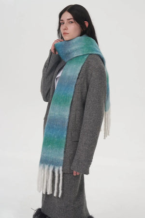 Gradient mohair fringe scarf in blue and green with white fringe, styled with a grey coat.