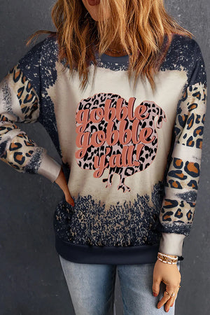 Black graphic sweatshirt with leopard print sleeves and "Gobble Gobble Y'all" text on a turkey shape.