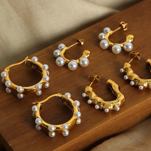Gold hoop earrings with scattered pearls and sculpted details.