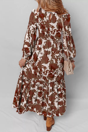 Charming floral maxi dress with billowy sleeves, smocked bodice, and tiered skirt in brown and beige cotton.