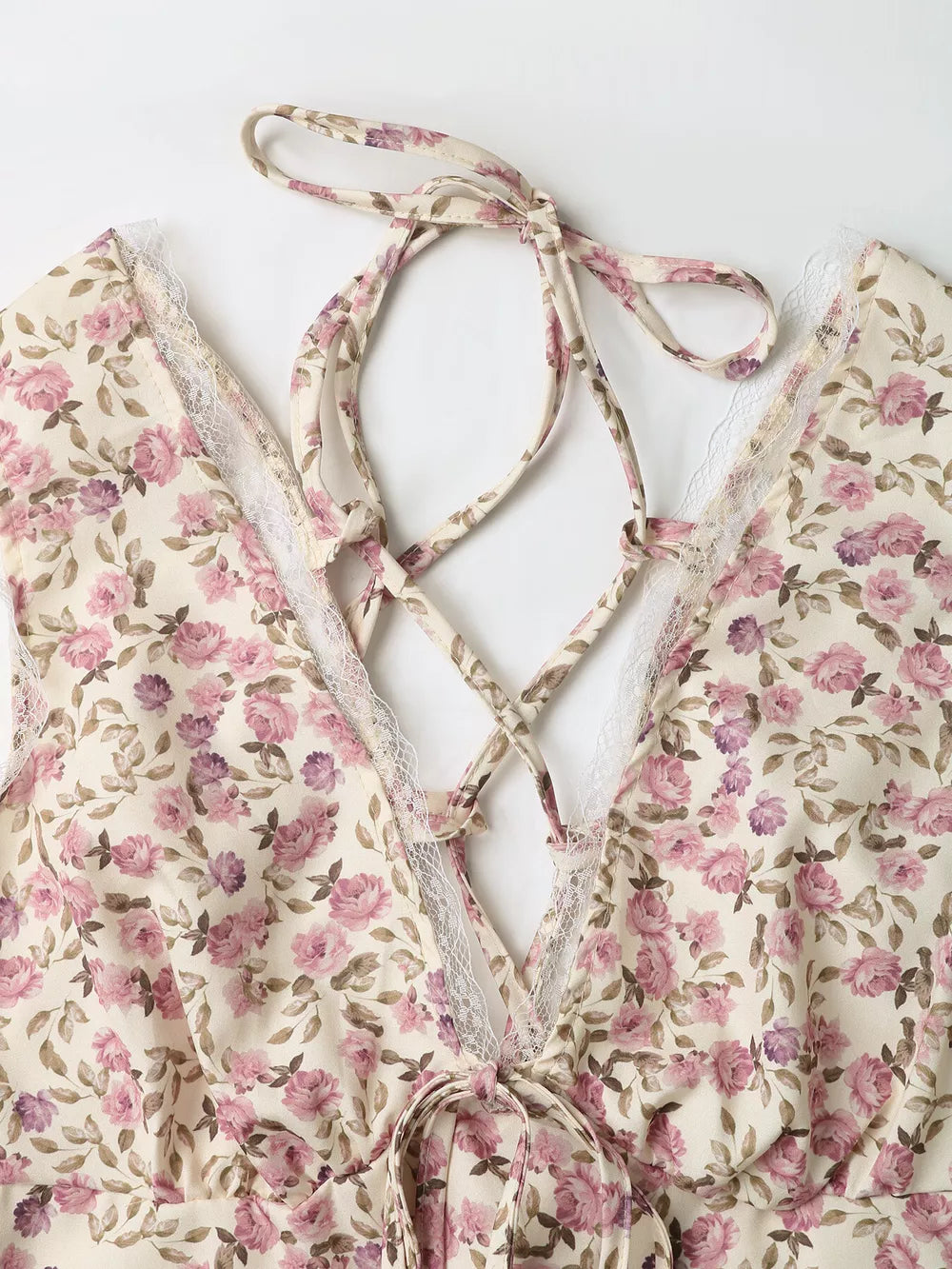 Floral lace tie mini dress with crisscross back detail and delicate lace trim.