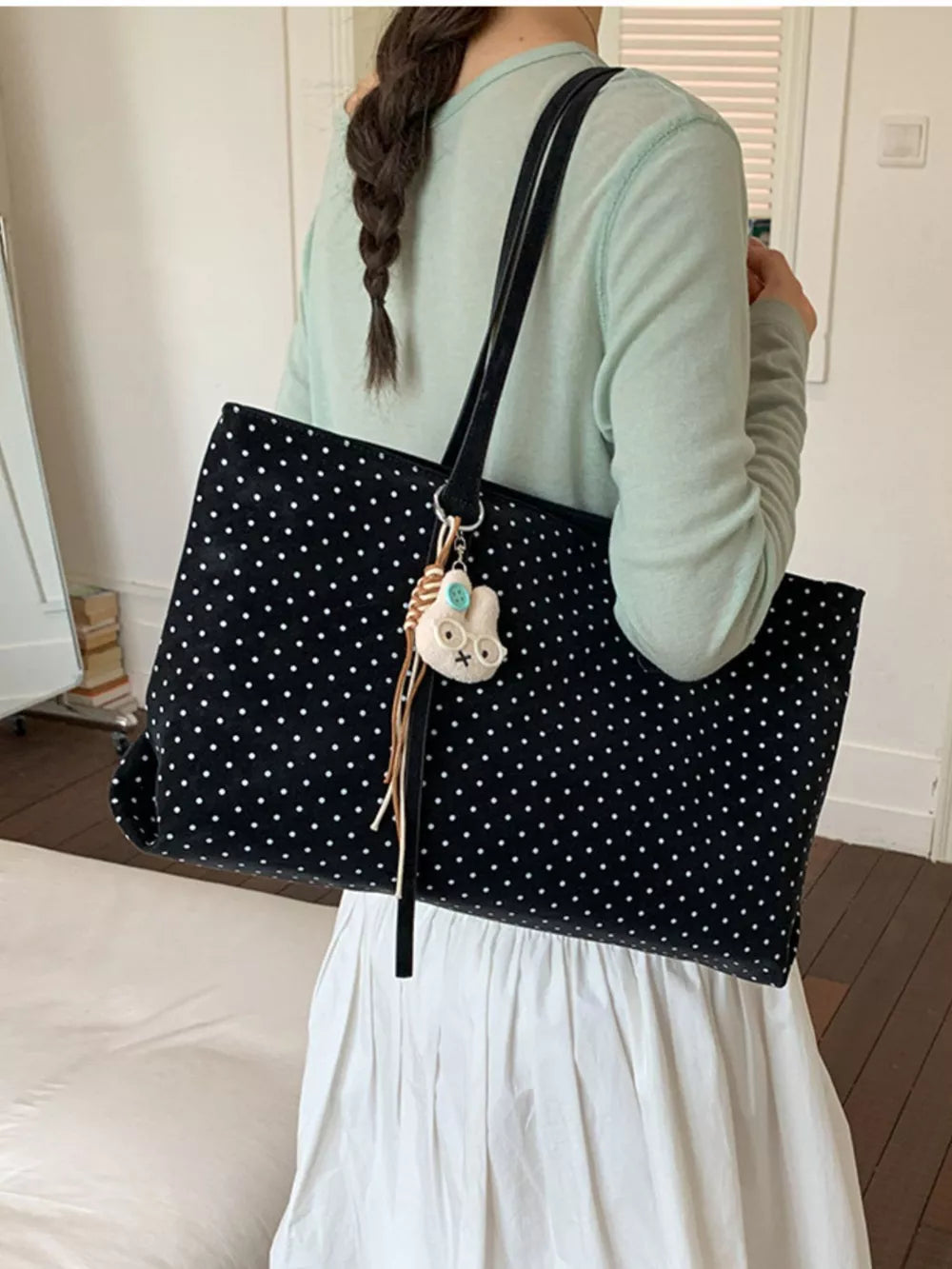 white handbag featuring shoulder straps and polka dot