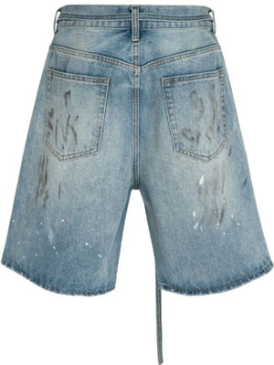 Distressed denim Bermuda shorts in medium wash with paint splatters and a tie detail.