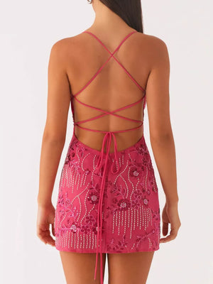 Fuchsia pink mini dress with floral embellishments and a lace-up back.
