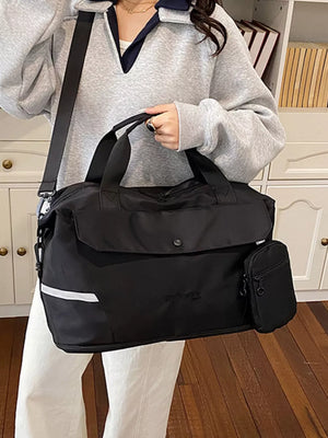 Black duffel bag with reflective stripe detail and detachable pouch, nylon material.