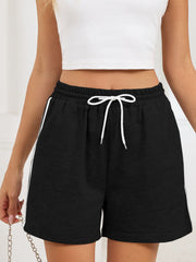Black jogger shorts with white drawstring and sporty side trim.