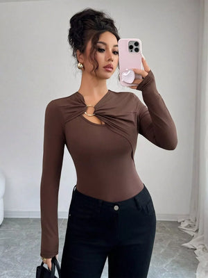Brown long-sleeve tee with asymmetrical cutout and gold ring detail.