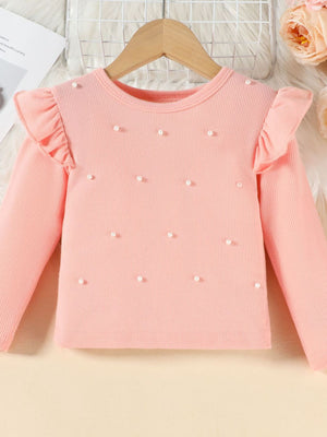 Pink ribbed long sleeve top with pearl embellishments and ruffled shoulders.