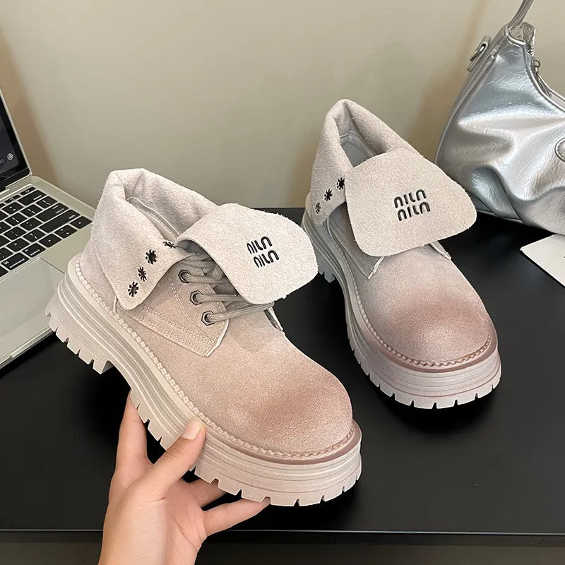 Light gray suede platform boots with fold-over cuffs and branding detail.