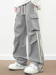 Oversized gray cargo pants with flap pockets and side stripe detail.