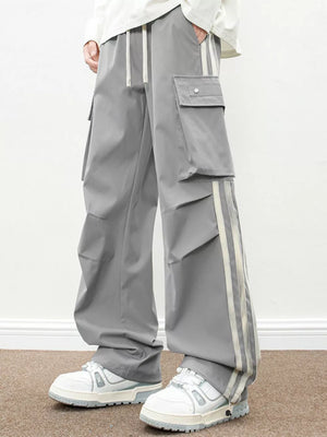 Oversized gray cargo pants with flap pockets and side stripe detail.
