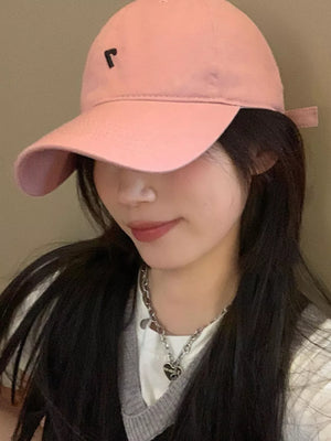 Pink cotton baseball cap with black embroidered detail and adjustable strap.