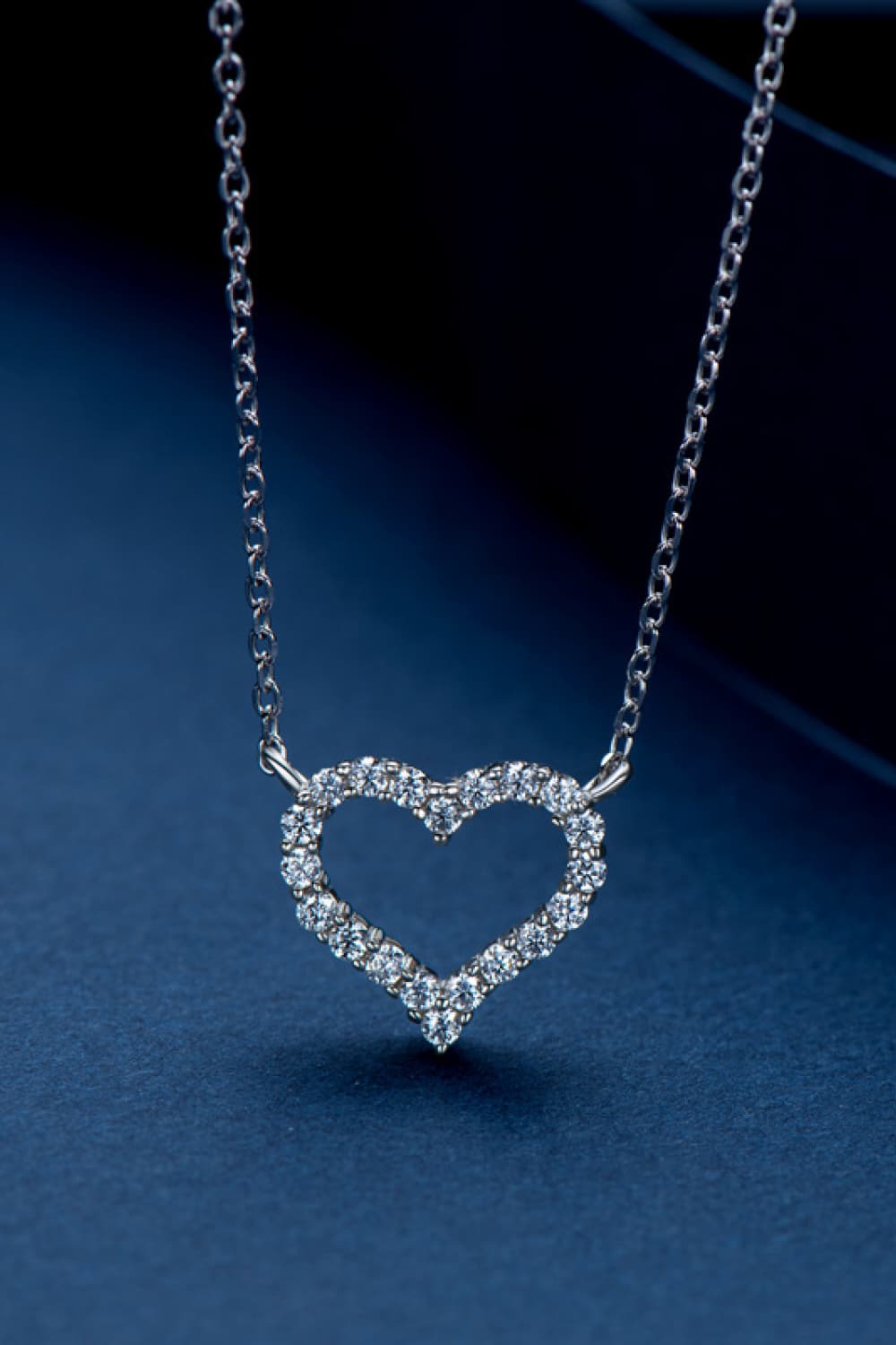 Silver heart pendant necklace with diamond embellishments on a delicate chain.