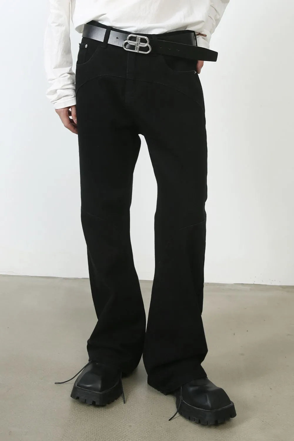 Black flared denim trousers with seam detail and a wide leg.