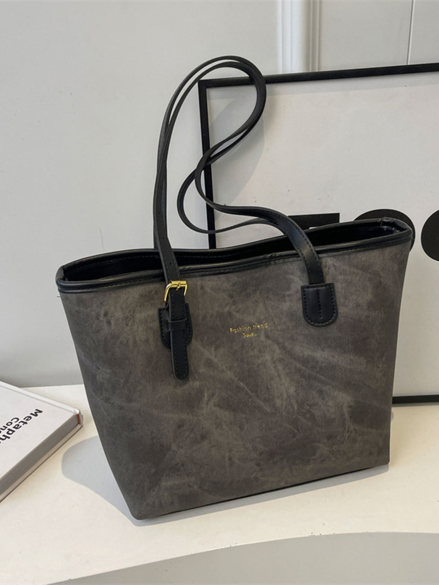 Distressed dark gray pu leather tote bag with buckle accents and gold logo detail.