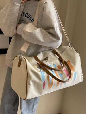 Off White canvas duffle bag with colorful star design and brown handles.