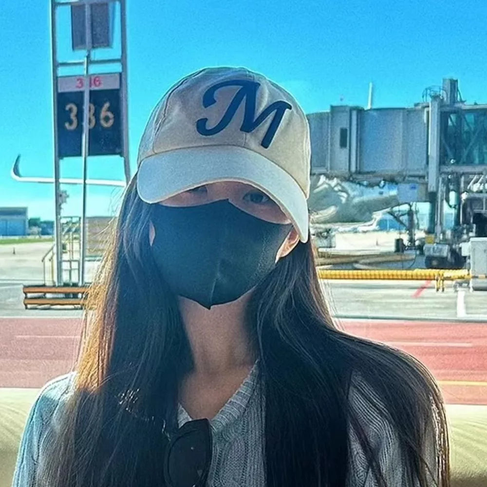 Embroidered M baseball cap in off-white with a contrasting brim and navy blue letter M.