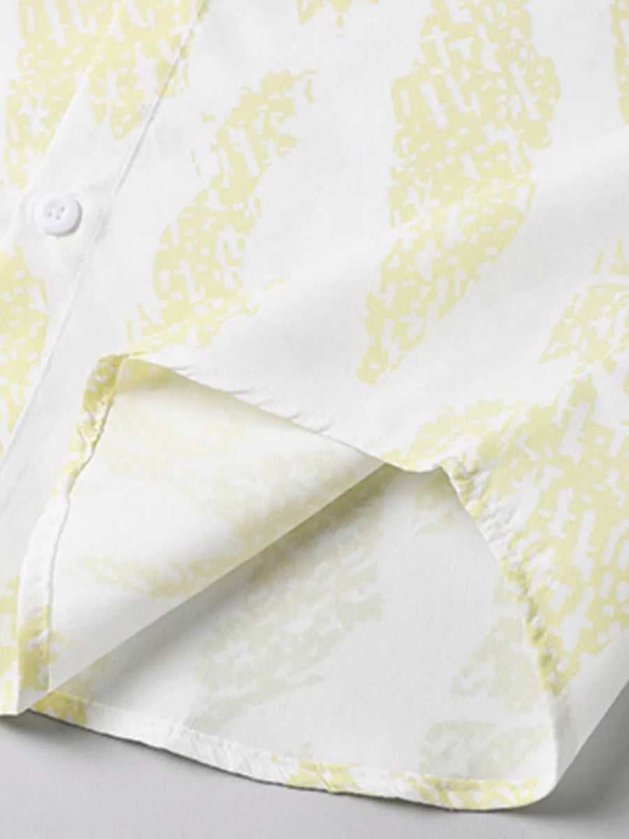 Cotton button-up shirt in Neon Yellow abstract pattern, showing hem detail.