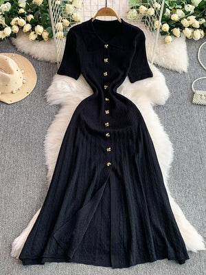 Black ribbed knit midi dress with collar, short sleeves, button detail and front slit.