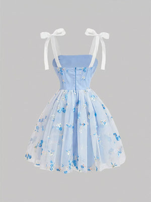 Blue floral embroidered mini dress with tie shoulder straps and a tulle overlay.