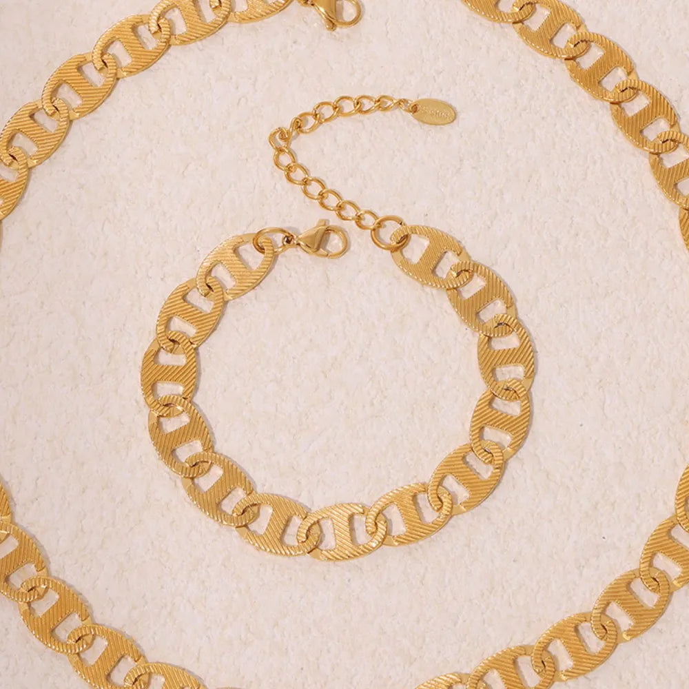 Textured gold oval link bracelet with adjustable chain and lobster clasp.