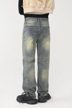 Distressed baggy denim jeans in medium wash with shredded knees and a casual fit.