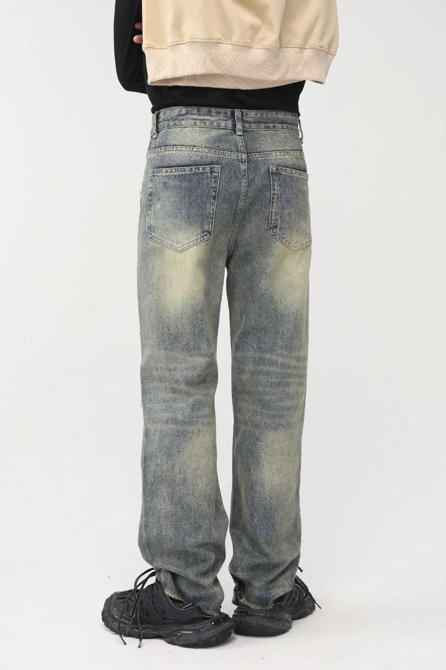 Distressed baggy denim jeans in medium wash with shredded knees and a casual fit.