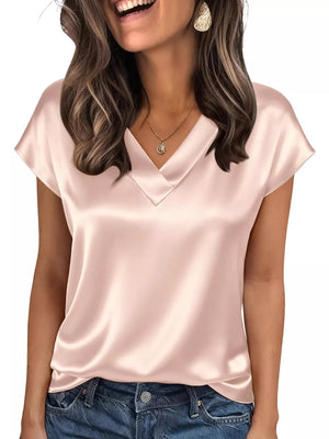 Lustrous satin V-neck blouse in champagne with short sleeves, styled with jeans.