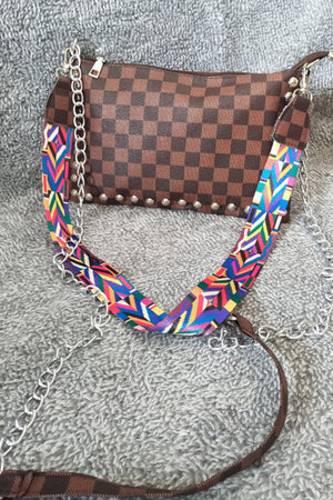 Brown checkered shoulder bag with studded detail and colorful geometric strap