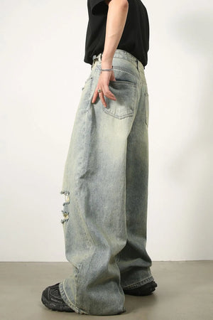 Oversized light wash denim palazzo trousers with distressed details and wide legs.