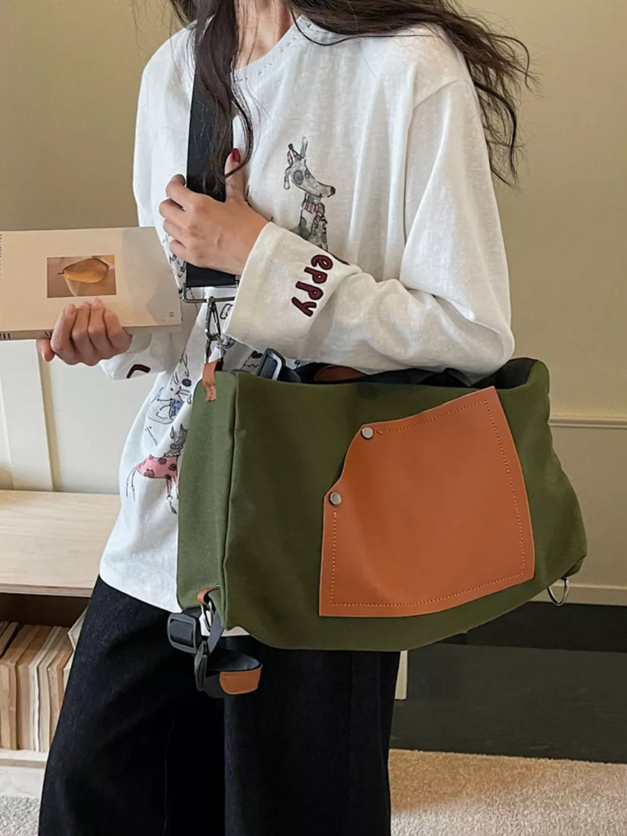 Green nylon crossbody bag with contrast tan pocket and silver hardware.
