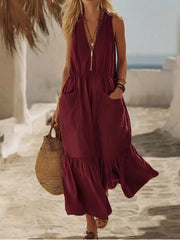 Burgundy maxi dress with ruffled hem, V-neck, zipper, and pockets.