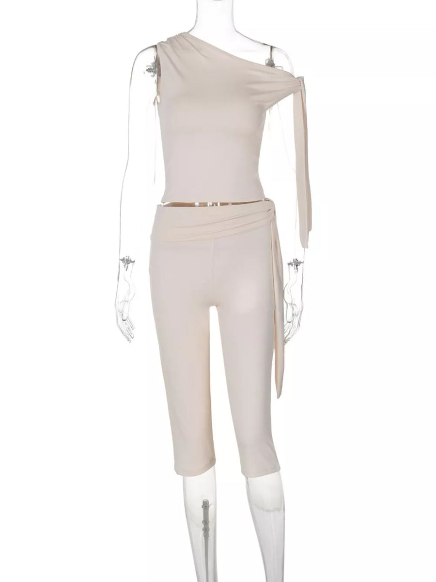 Apricot asymmetrical one-shoulder top with tie detail and matching capri pants.