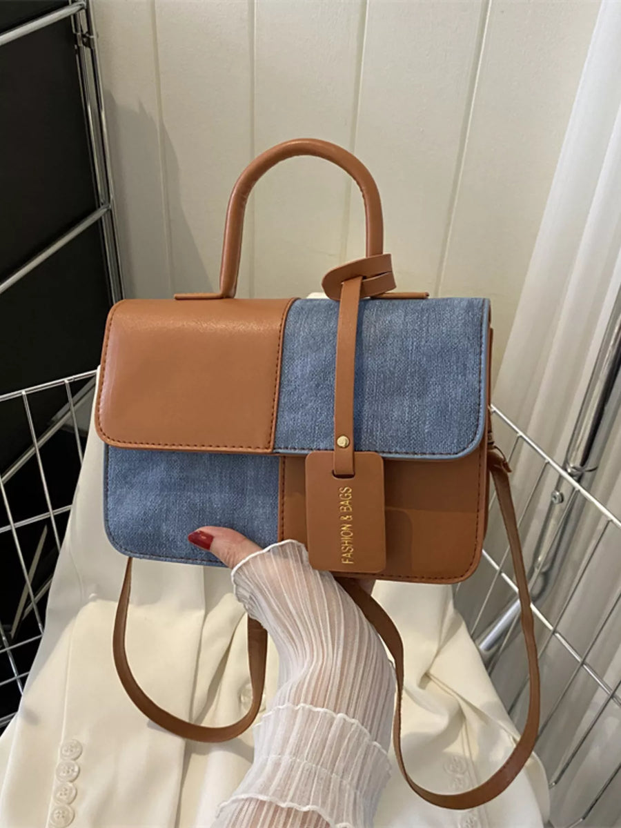 Chic two-tone PU leather handbag with denim accents and a top handle.