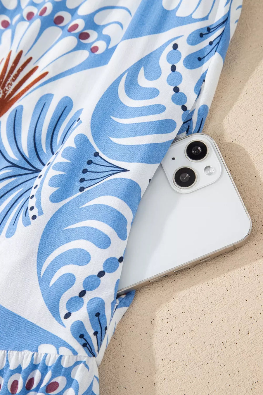 Botanic print ruffle dress with flutter sleeves, showing a side pocket holding a phone.