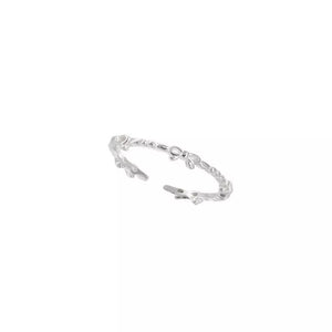 Delicate sterling silver ring with a repeating bow pattern.