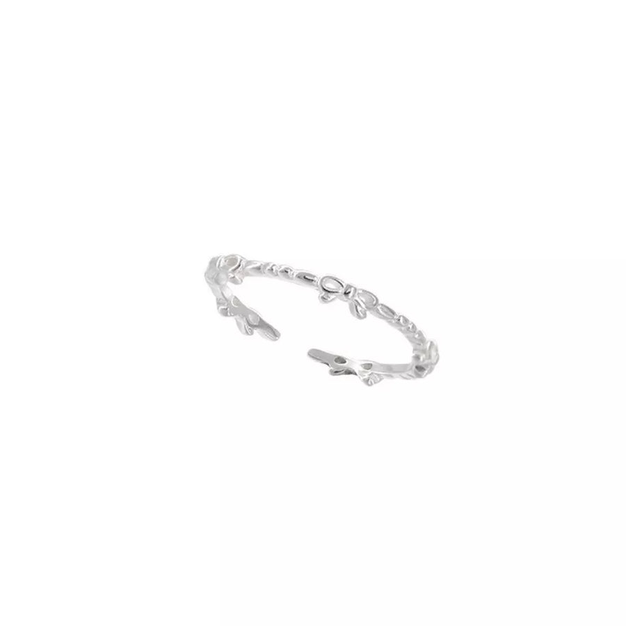 Delicate sterling silver ring with a repeating bow pattern.