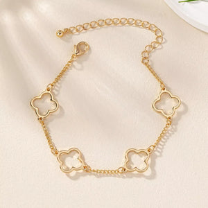 Gold four leaf clover charm bracelet with dainty chain and lobster clasp.