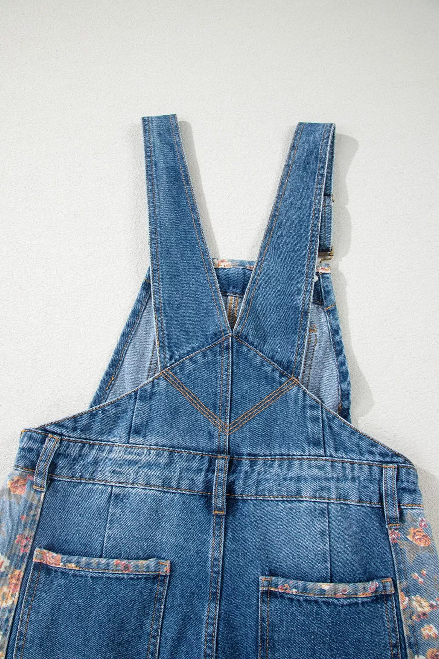 Denim overalls with vintage floral print trim on pockets and sides.