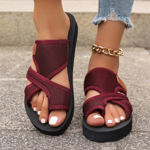 Cross-strap sporty slides in deep purple with a textured sole and branding detail.