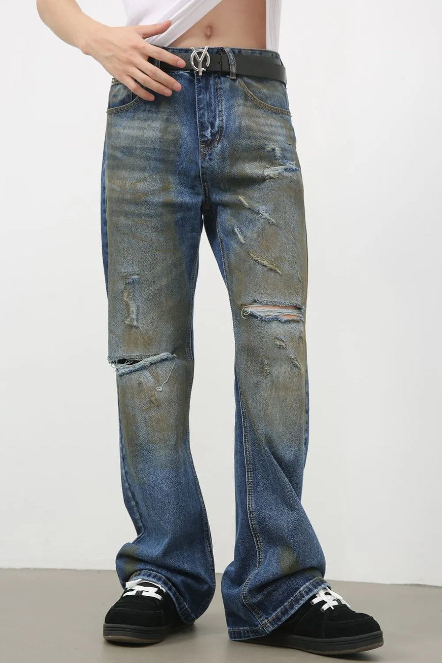 Distressed flare jeans in medium wash denim with patina effect and ripped details.