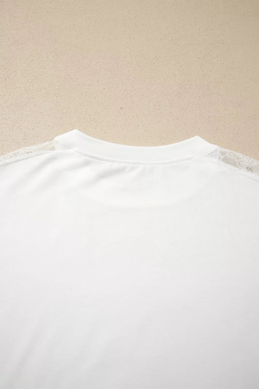 White long sleeve shirt with delicate lace shoulder detail and crew neckline.