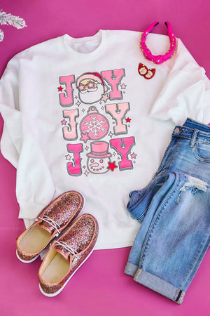 White crewneck sweatshirt with pink "JOY" graphic featuring Santa, a snowman, and a snowflake ornament.