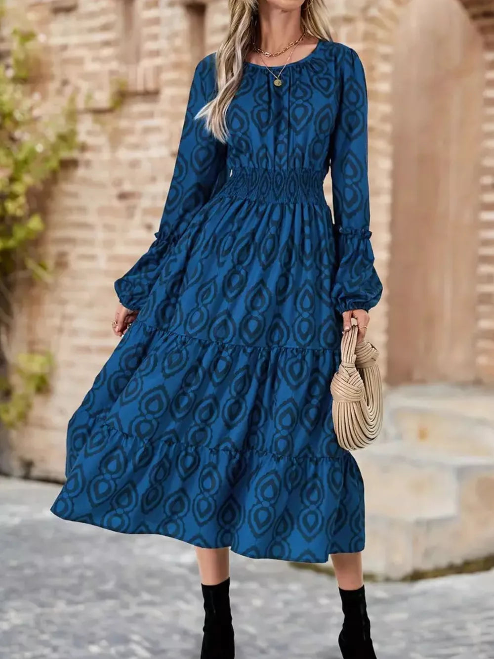 Blue abstract pattern midi dress with smocked waist and tiered skirt.